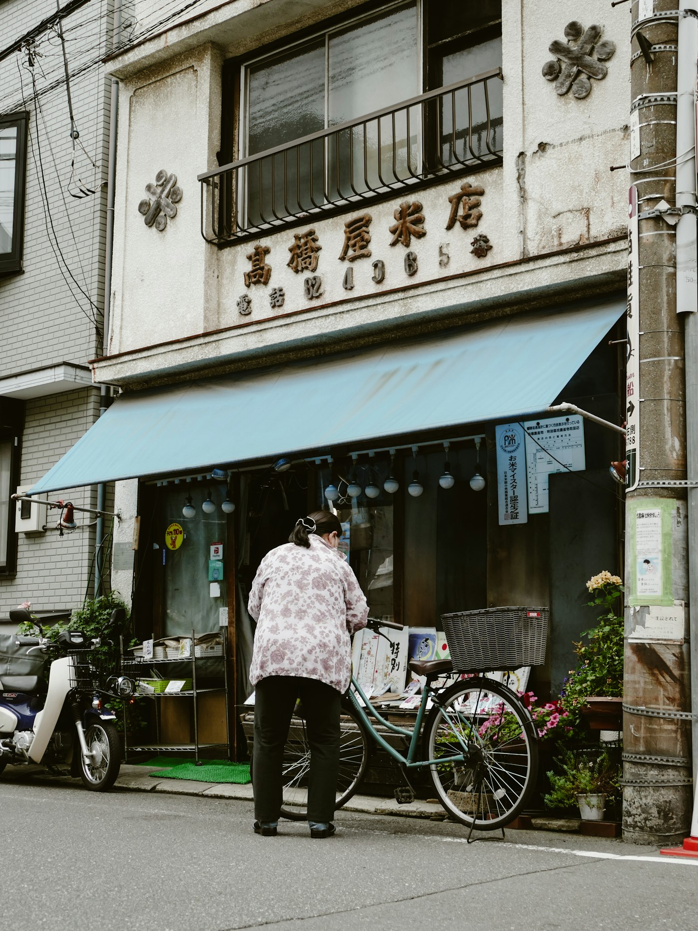 店先に自転車を停めるフミ